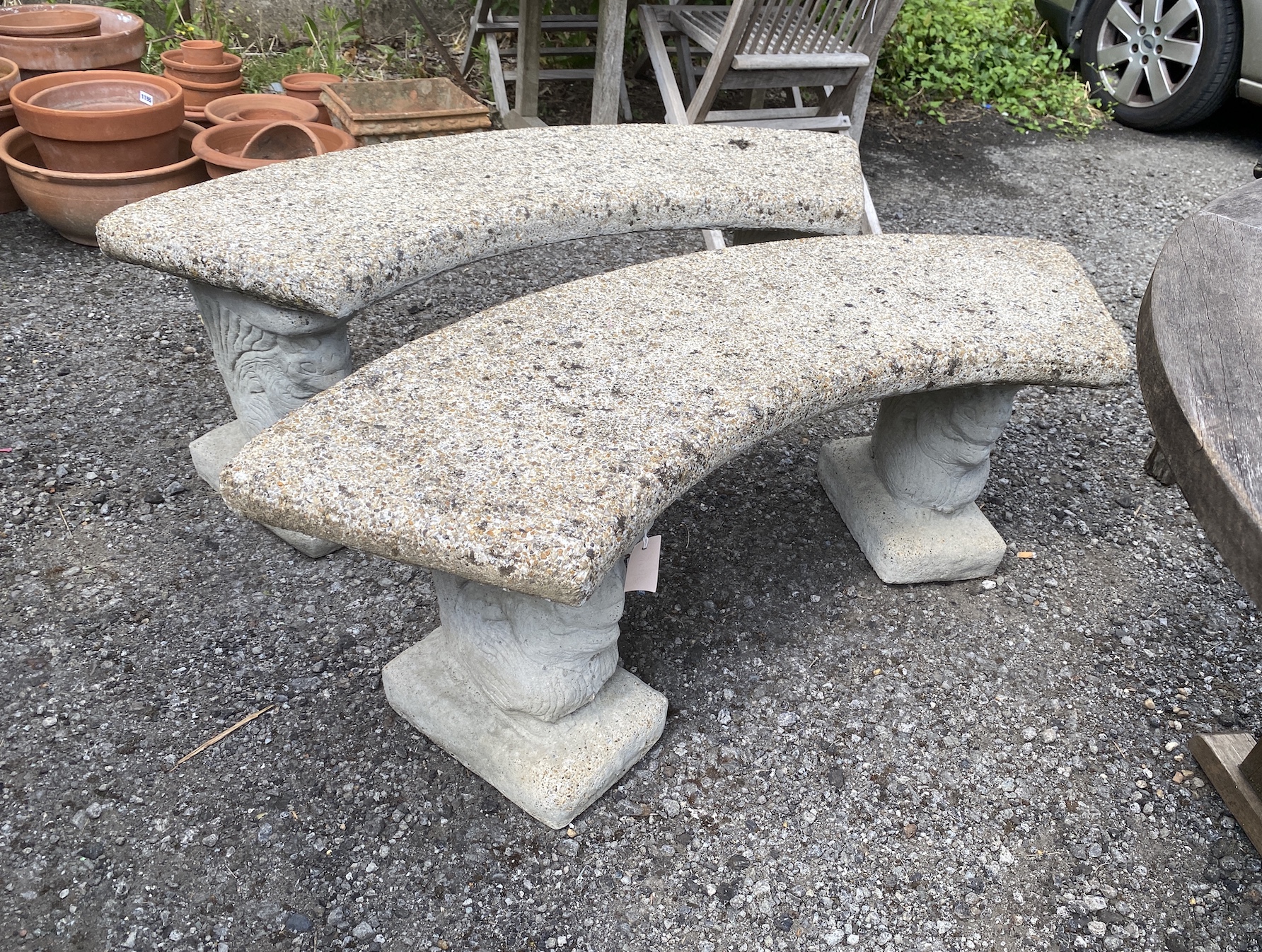 A pair of curved reconstituted stone garden benches, width 122cm, height 45cm